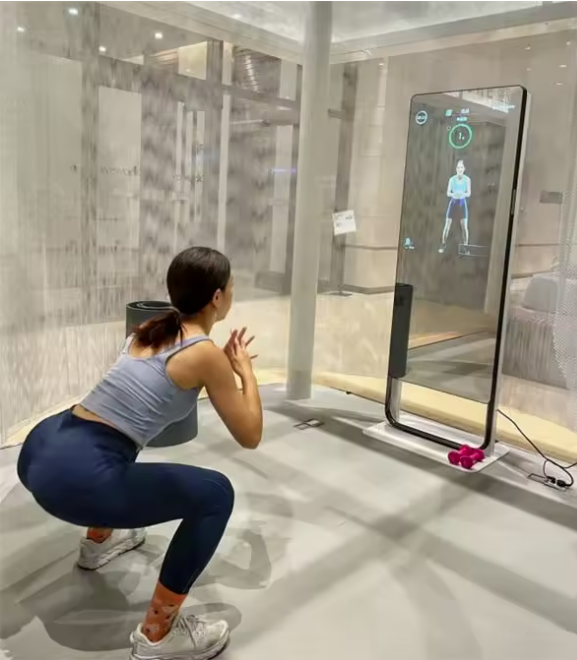 Woman performing squats in front of a smart fitness mirror for muscle training